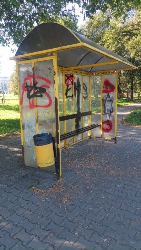 przysanek autobusowy z pomalowanymi graffiti szybami