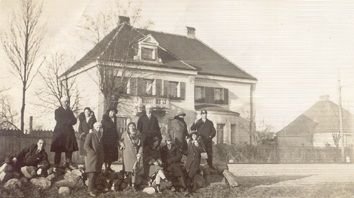 fotografia przedstawiająca grupę osób stojących przed budynkiem.