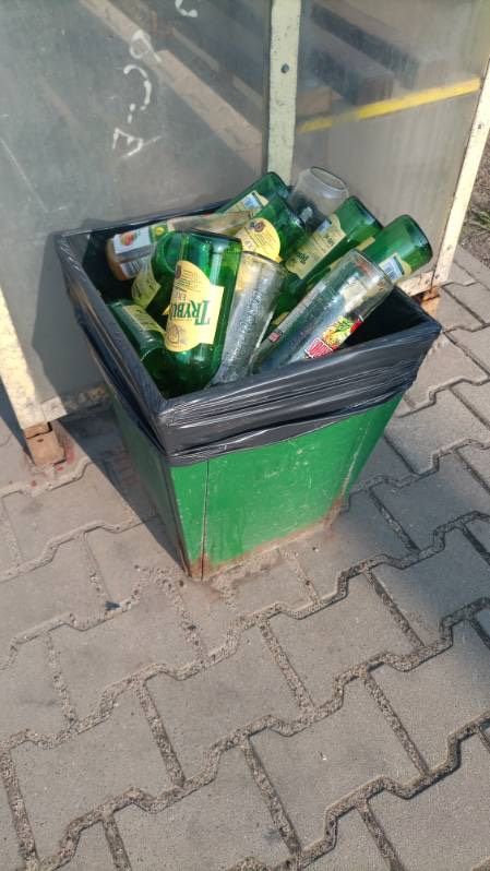 szklane butelki w koszu na śmieci