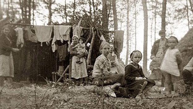 Czarno-białe zdjęcie przedstawiające obozowisko w którym przebywają kobiety i dzieci