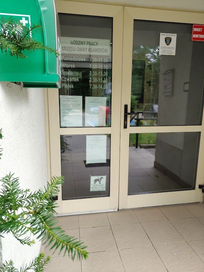 zdjęcie drzwi wejściowych do urzędu z tabliczką informująca o możliwości wejścia z psem asystującym