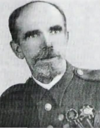 Czarno- białe zdjęcie przedstawiające mężczyznę w mundurze