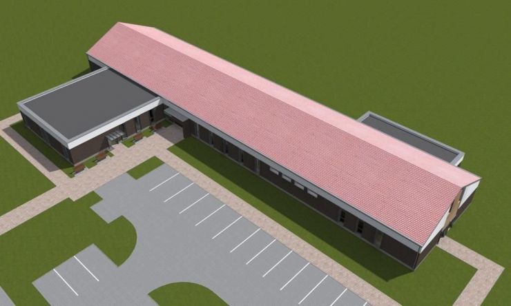 Wizualizacja budynku nowego ośrodka zdrowia przedstawiająca budynek w kształcie litery L. Wokół budynku parking, trawnik, nasadzenia i ławki
