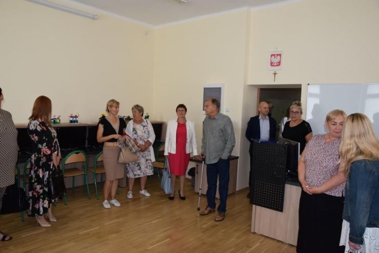 Grupa ludzi - Radni Gminy Ksawerów stoją w komputerowej sali lekcyjnej