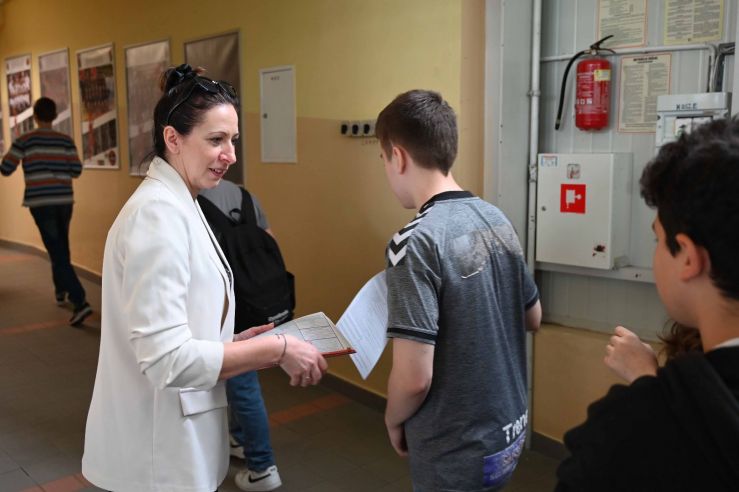 warsztaty kobieta rozdaje ulotki