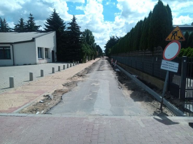 Fragment remontowanej drogi. Z lewej strony ukończony betonowy pas przysypany pisakiem.
