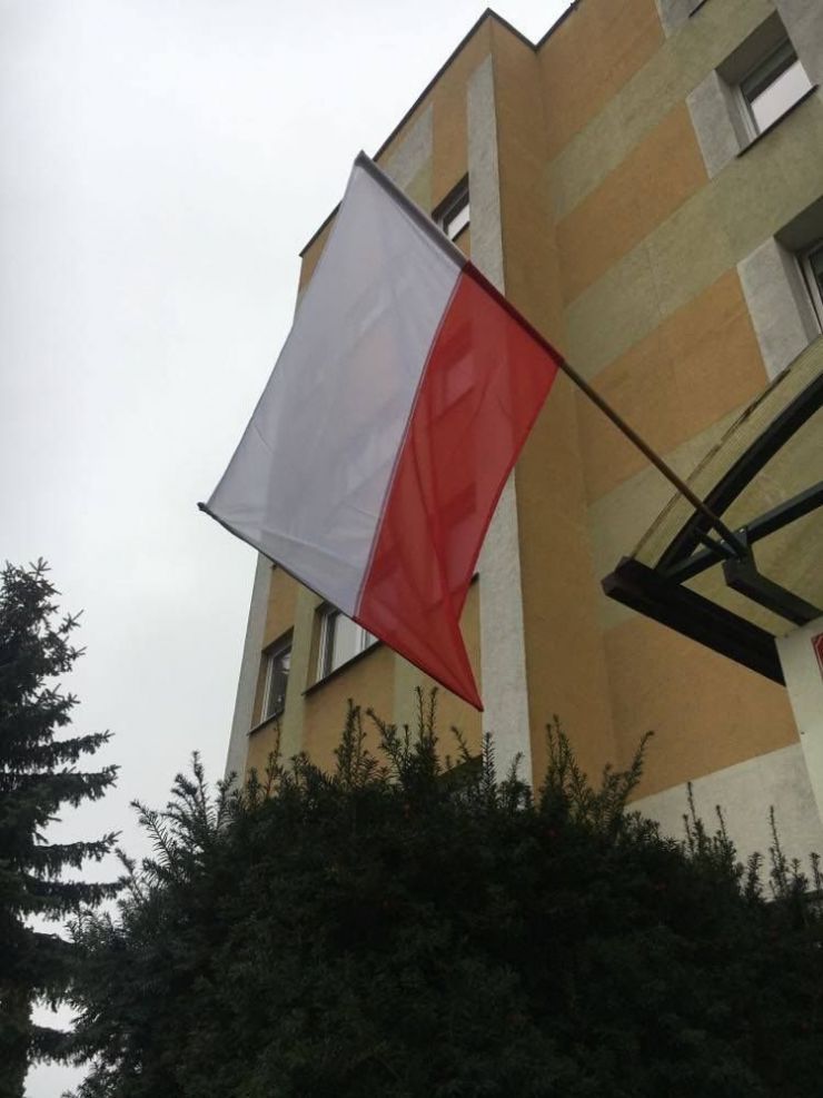 wisząca flaga Polski w tle budynek