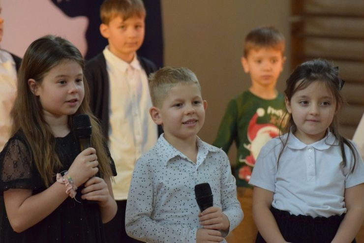 Dzieci trzymające mikrofon podczas występu.