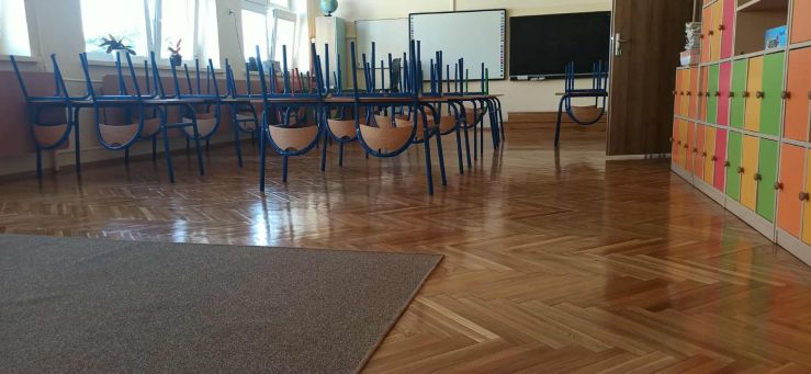 klasa szkolna ławki z krzesłami na nich 