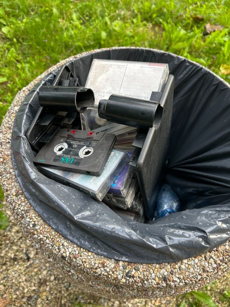 kosz na śmieci a w nim kasety magnetofonowe