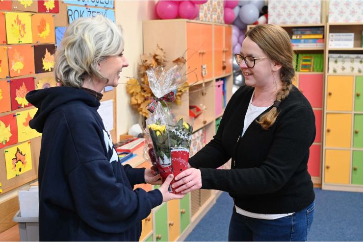 kobieta kobiecie wręcza kwiat