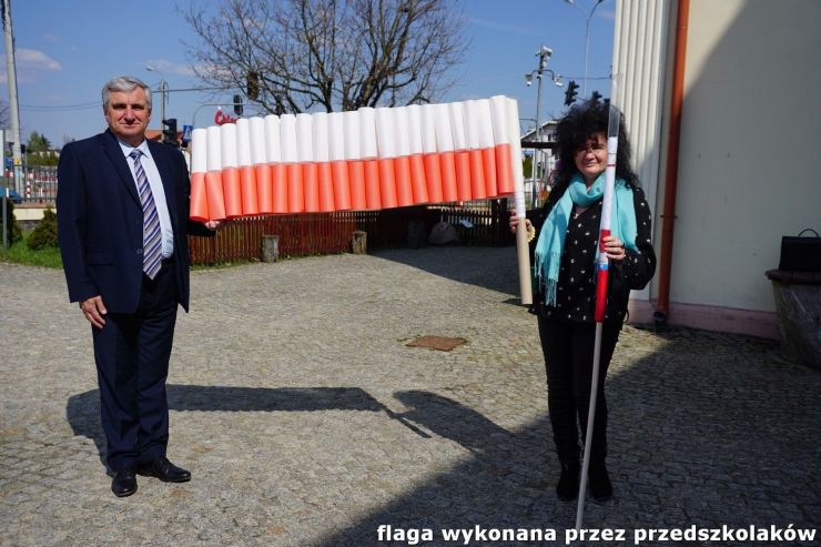 Wójt z Nauczycielką p.Siarą trzymają flagę polski wykonaną przez przedszkolaków