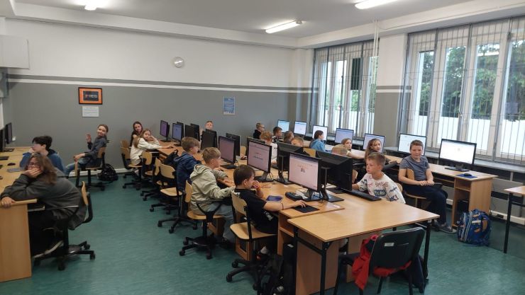 podczas lekcji dzieci siedzą w pracowni informatycznej