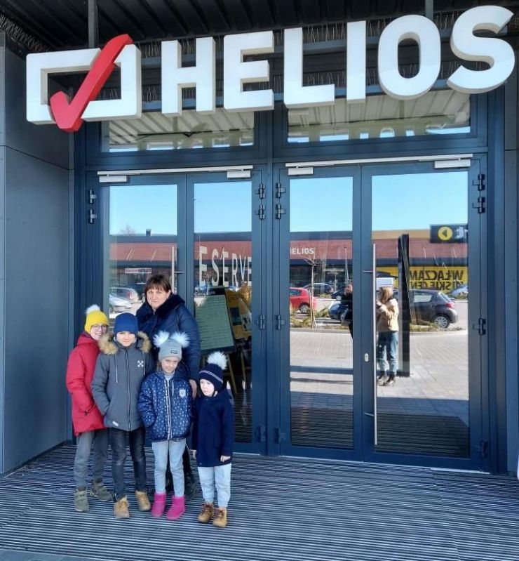 kobieta z czwórką dzieci stoją przed wejściem do kina Helios