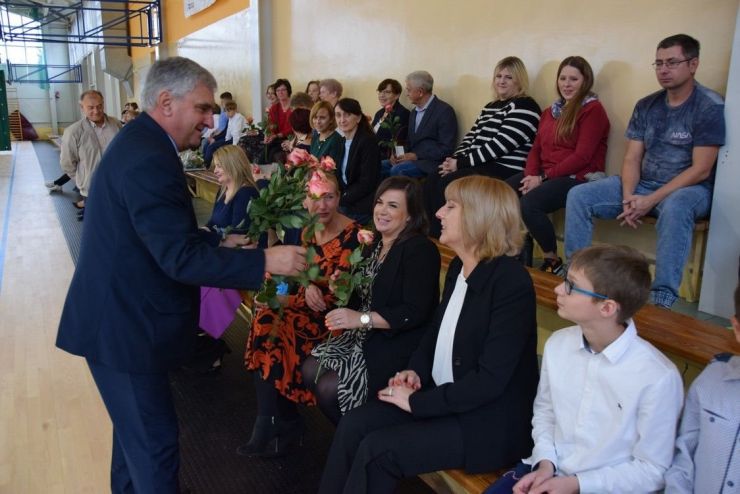 Mężczyzna wręcza siedzącym kobietom róże.