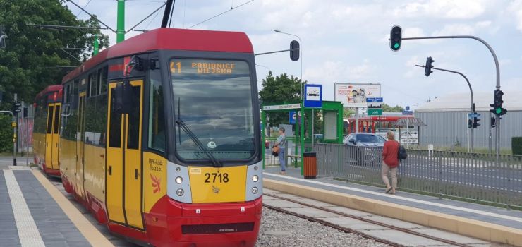 Czerwono-żółty tramwaj na przystanku Mały Skręt w kierunku Pabianic. W tle przystanek i sygnalizacja świetlna