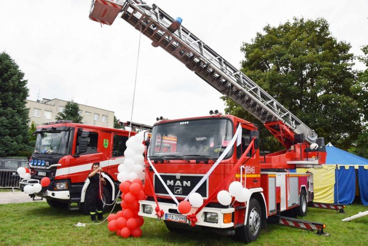 Wóz strażacki udekorowany biało-czerwonymi balonami i wstęgą