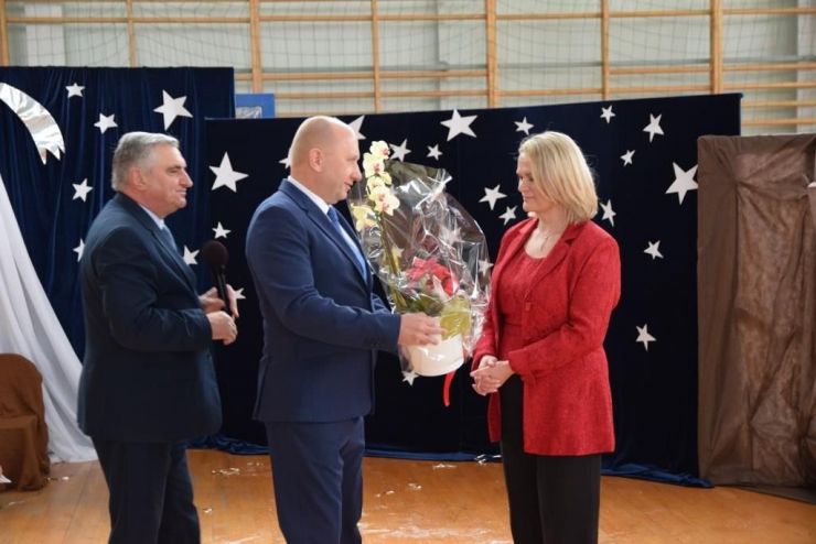 Wójt i Przewodniczący Rady wręczają kwiaty dyrektor szkoły