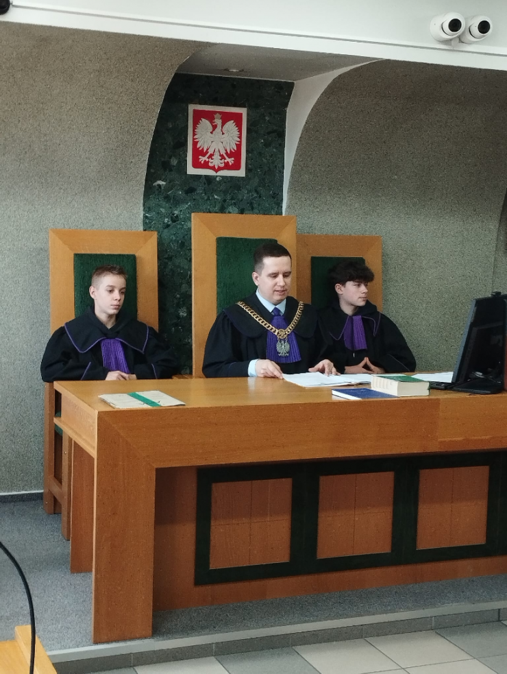 na sali sądowej sędzia i dwoje nastolatków siedzą na sali sądowej