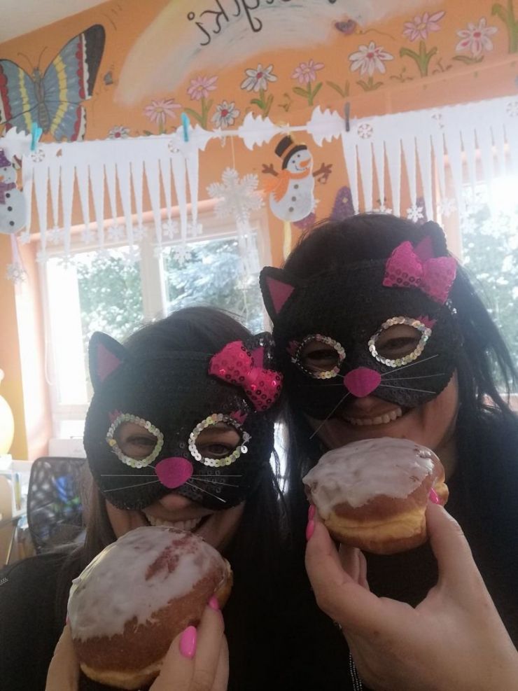 nauczycielki w maskach kotów jedzące pączki
