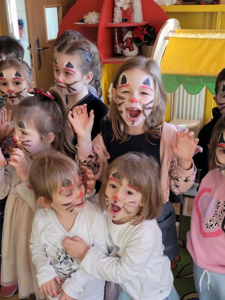 Grupa przedszkolaków z pomalowanymi kocimi twarzami