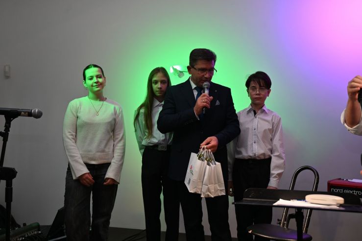 cztery osoby na scenie podczas przemówienia 