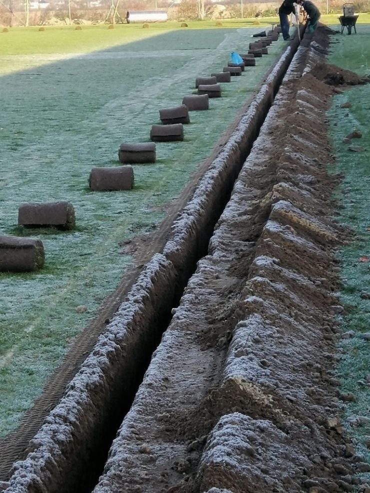Wzdłuż boiska trawiastego wykopany dół w celu montażu systemu nawadniającego