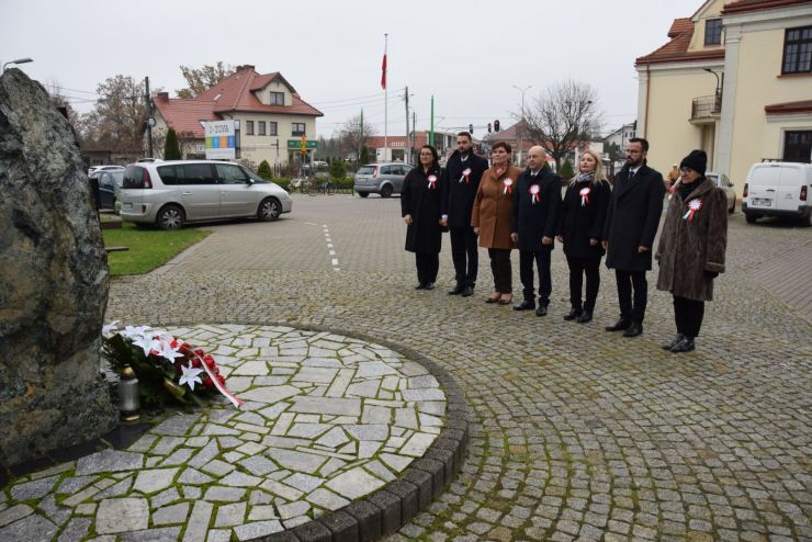 Delegacja z gminy składa kwiaty przed pomnikiem.