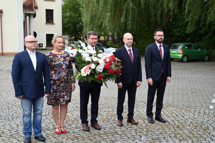 Jedna kobieta i czterech mężczyzn podczas składania kwiatów.