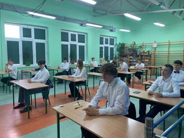 uczniowie klasy 8 siedzący w ławkach przed rozpoczęciem egzaminu