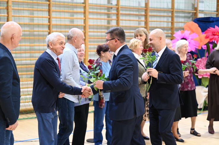 grupa ludzi podczas wręczania kwiatów